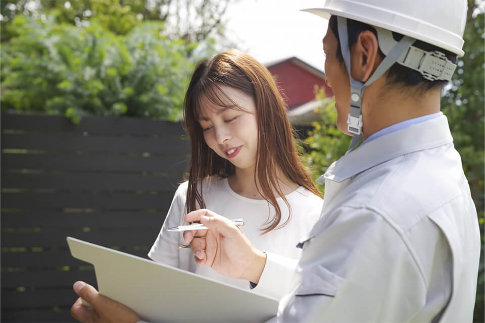 施工プランを説明する作業員と笑顔で聞く女性