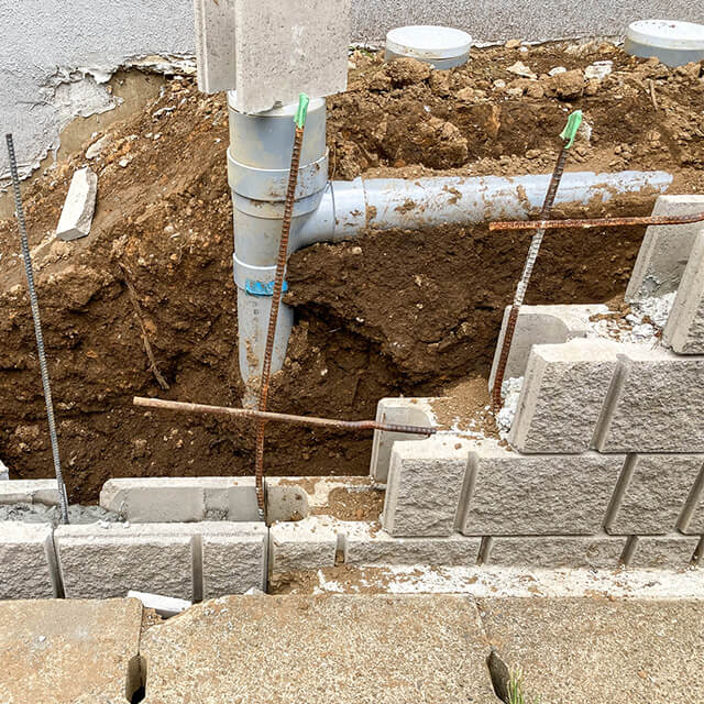 住宅外構まわりで行われている配管とブロック塀の改修工事