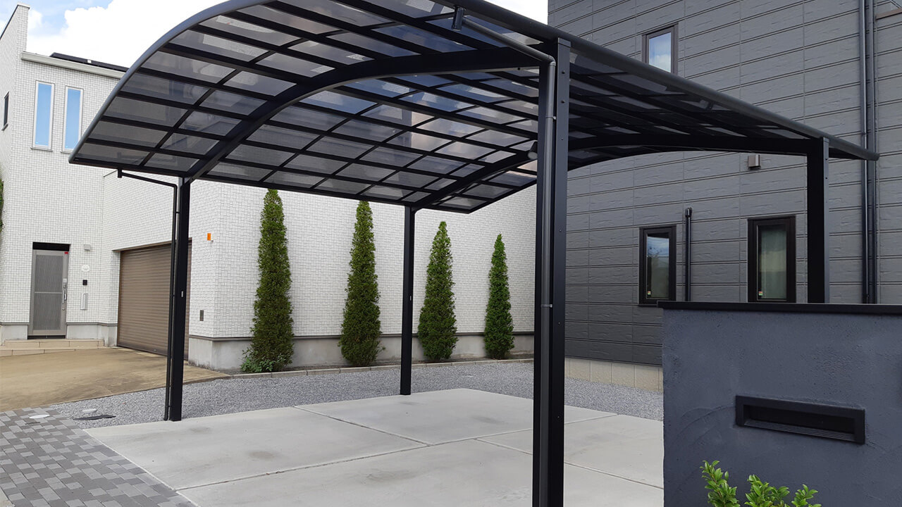 住宅前に設置されたスタイリッシュなカーポートと駐車スペース