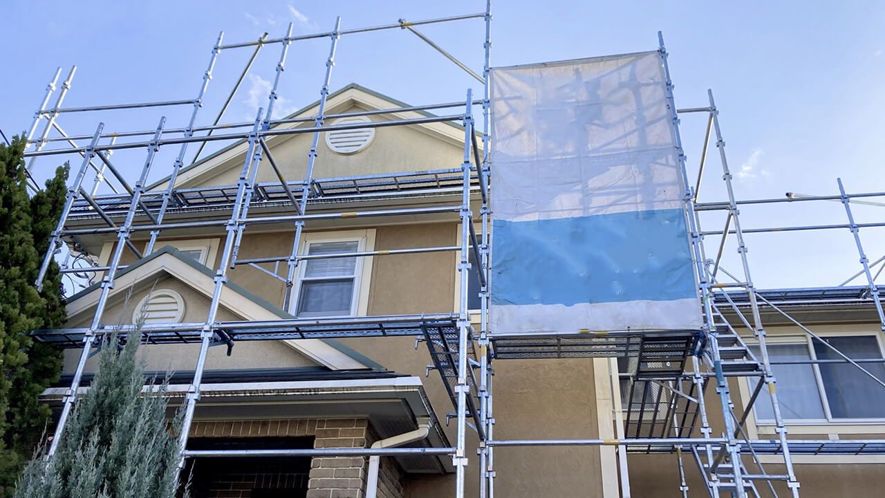 戸建住宅の外壁に設置された足場と養生シート